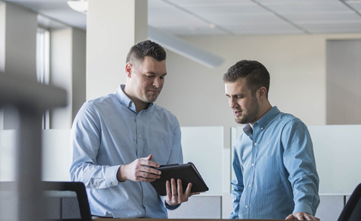 Two consultants discussing through a tablet